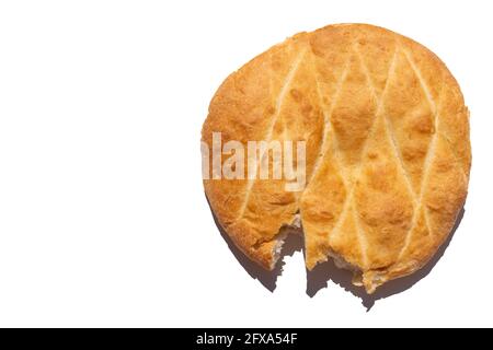 Freshly baked homemade round wheat bread broken off one edge isolated on white background, top view, copy space. Bitten off bread. Healthy food concep Stock Photo