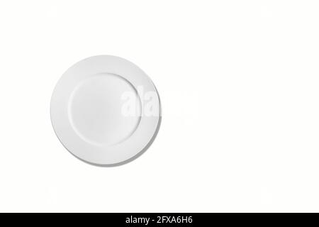 Empty ceramic round plate isolated on white background. View from above. Stock Photo