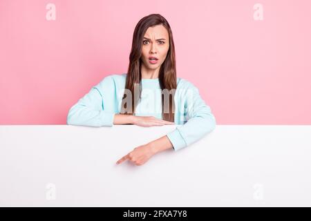 Portrait of attractive lady direct finger empty space promo staring wear sweater isolated on pink color background Stock Photo