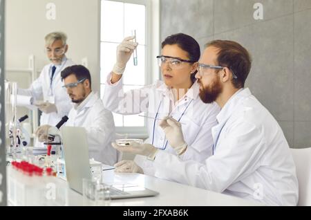 Group of serious scientists working on new chemicals or vaccines in their laboratory Stock Photo