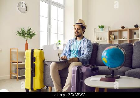 Young man planning holiday trip and using laptop to look for rentals or book hotel room Stock Photo