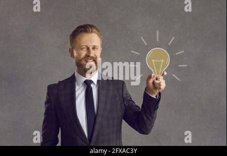 Happy businessman holding light bulb as concept of business idea, solution and innovation Stock Photo