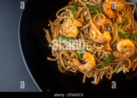 noodles with paste, shrimp and herbs on black plate, macro Stock Photo