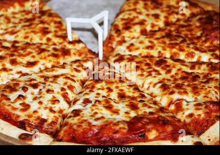 close-up of a sliced pizza, still in delivery box, with one slice gone. Stock Photo