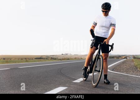 Happy cyclist in sport outfit standing outdoors Stock Photo