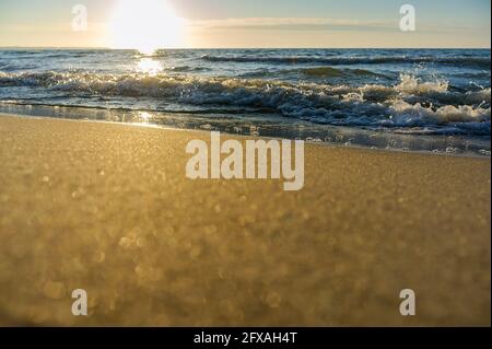 Sunset over the sea. Reflection of sunlight in the sea waves. Red and yellow sky in the rays of the sunset. Stock Photo