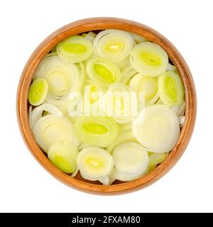 Leek slices, in a wooden bowl. Chopped leaf sheaths and cross sections of Allium ampeloprasum, a crunchy and firm vegetable. Stock Photo