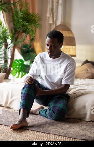 African man suffering from pain in leg. Stock Photo