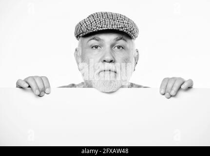 Senior bearded emotional man peek out of banner place announcement. Pensioner grandfather in vintage hat poster information copy space. Elderly person Stock Photo