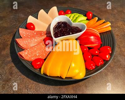 Plate on which various foods such as vegetables and vegan sausages are decoratively arranged. Stock Photo
