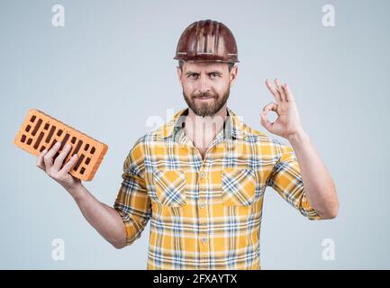 professional bricklayer show ok gesture. builder engineer. labor or workers day. Stock Photo