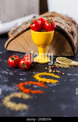 Wooden spoon and spices with cherry tomatoes Stock Photo