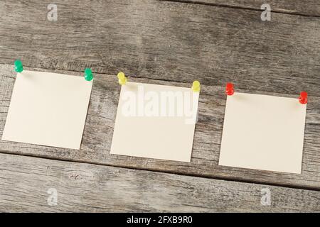 Square stickers pinned in a row on a wooden table. The concept of setting goals and objectives Stock Photo