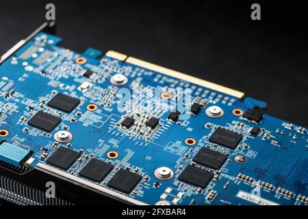 A blue board with chips and a gaming graphics card processor. Progressive cooling system for the video chip, processor and memory. Computer Details Stock Photo