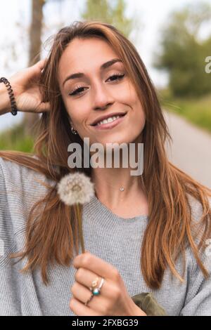 Beautiful woman with hand in hair in nature Stock Photo