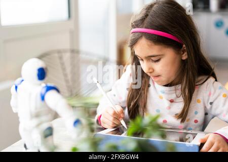 Girl using digital tablet while studying at home Stock Photo