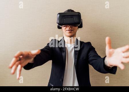 Businesswoman gesturing while using virtual reality headset in office Stock Photo