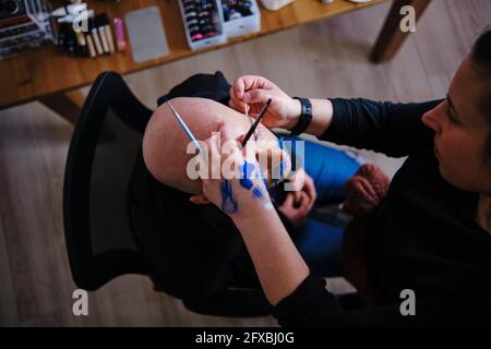 Make-up artist working on model in studio Stock Photo