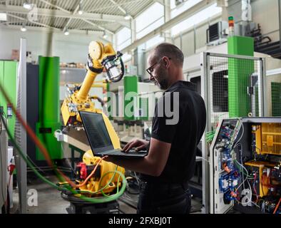 Male Engineer using laptop in industry Stock Photo
