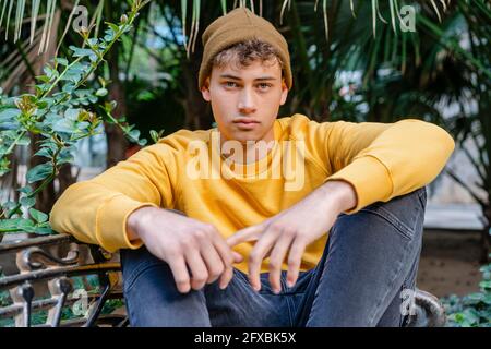 Young man wearing knit hat while sitting at park Stock Photo