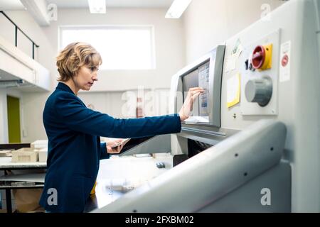 Expertise operating printing machine in workshop Stock Photo