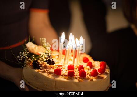 Birthday candles burning on cake during celebration at home Stock Photo