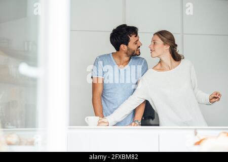 Romantic young couple in kitchen at home Stock Photo