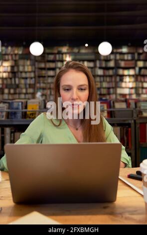 Beautiful woman using laptop in library Stock Photo