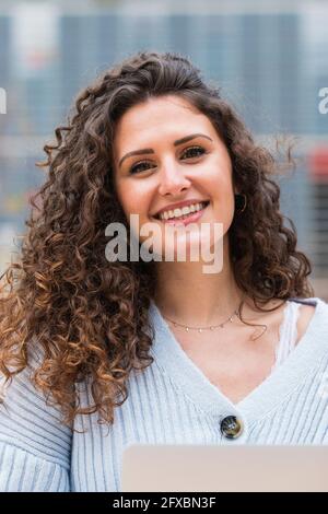 Young smiling woman with brown curly hair Stock Photo