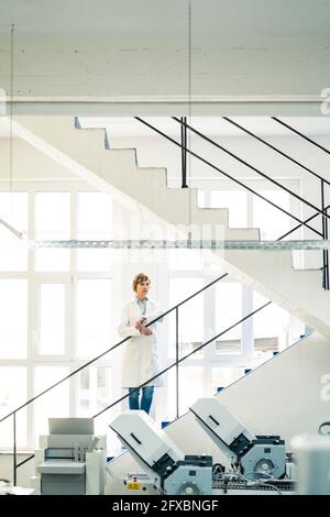 Mature female entrepreneur standing in printing factory Stock Photo