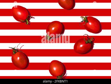 Studio shot of cherry tomatoes lying against white and red striped background Stock Photo