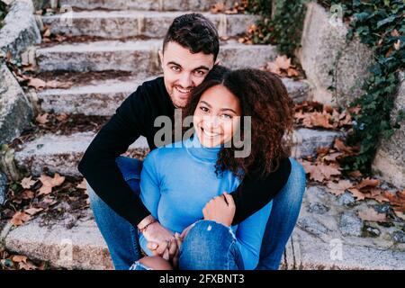 Young couple sitting together on steps Stock Photo