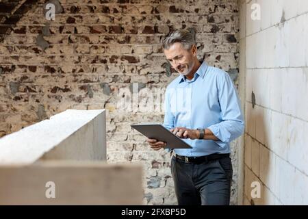 Male architect using digital tablet at construction site Stock Photo
