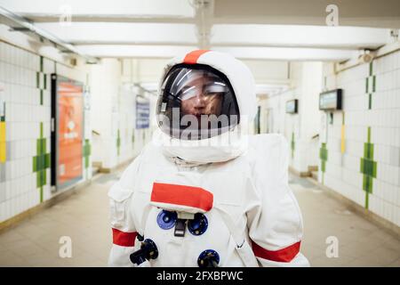 Young female astronaut standing in subway Stock Photo