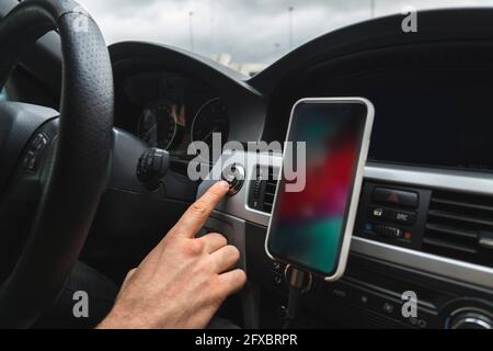 Man touching start button in car Stock Photo