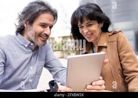 Mature business couple working on digital tablet at terrace Stock Photo