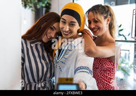 Smiling female friends making payment at restaurant Stock Photo