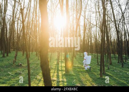 Young astronaut in space suit exploring woodland Stock Photo