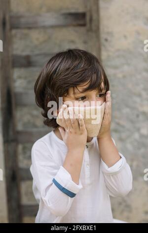 Cute boy covering his face Stock Photo - Alamy