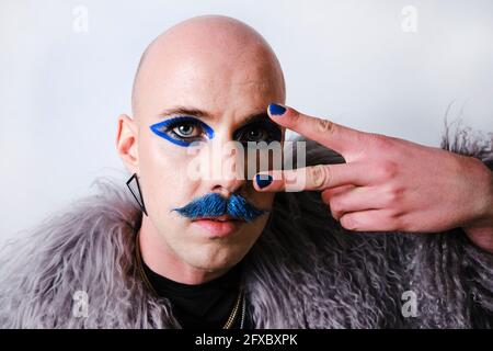Man with mustache showing peace sign over white background Stock Photo
