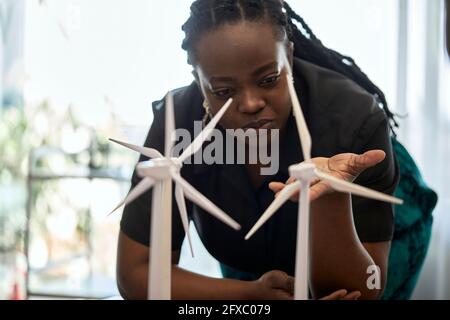 Woman examining wind turbine models at coworking office Stock Photo