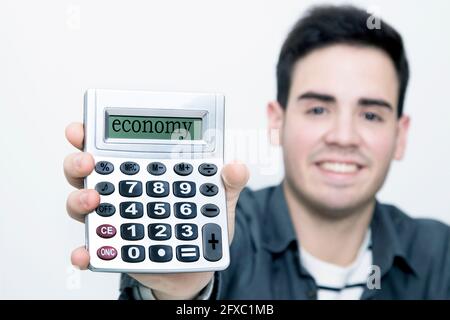 calculator in first plane with man to the background smiling Stock Photo