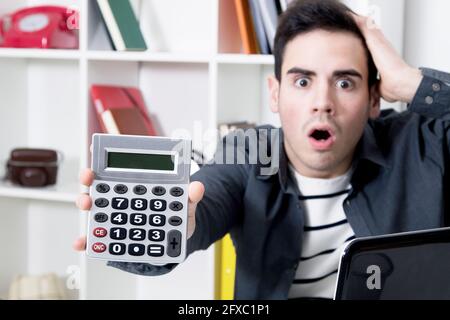 calculator in first plane with man afraid Stock Photo
