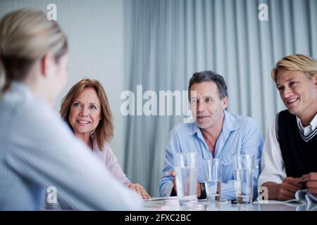 Smiling male and female entrepreneurs discussing during meeting at office Stock Photo