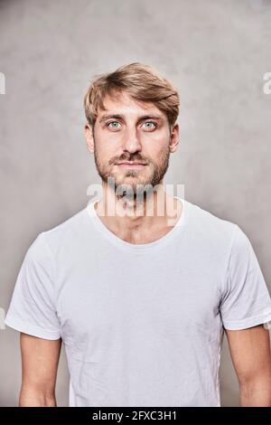 Handsome bearded man staring in front of wall Stock Photo