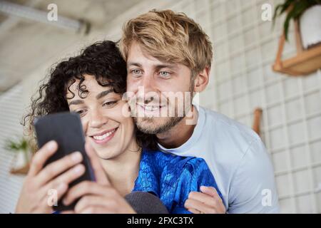 Young woman with boyfriend using mobile phone Stock Photo