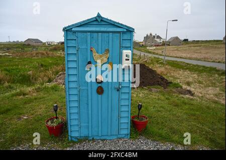 Blue eggs for sale shed in Habost, Isle of Lewis, Outer Hebrides, Scotland. Artwork of eggs and hen on outside. Blurred rural and village background. Stock Photo