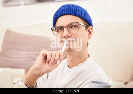 Thoughtful man looking away while sitting at home Stock Photo