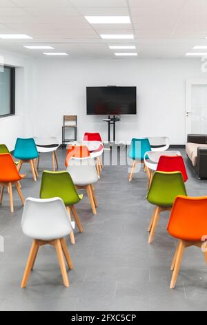 Television set and empty chairs arranged during conference event in classroom Stock Photo