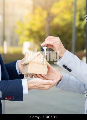 Mature businesswoman receiving house model and key from estate developer Stock Photo
